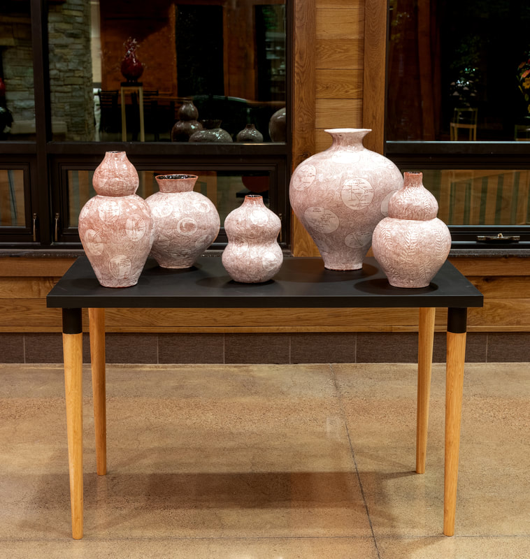 five terra cotta vases on a table 