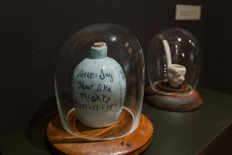 porcelain jug with cobalt decorations and clay pipe with the head of a mudmaid as the bowl. 