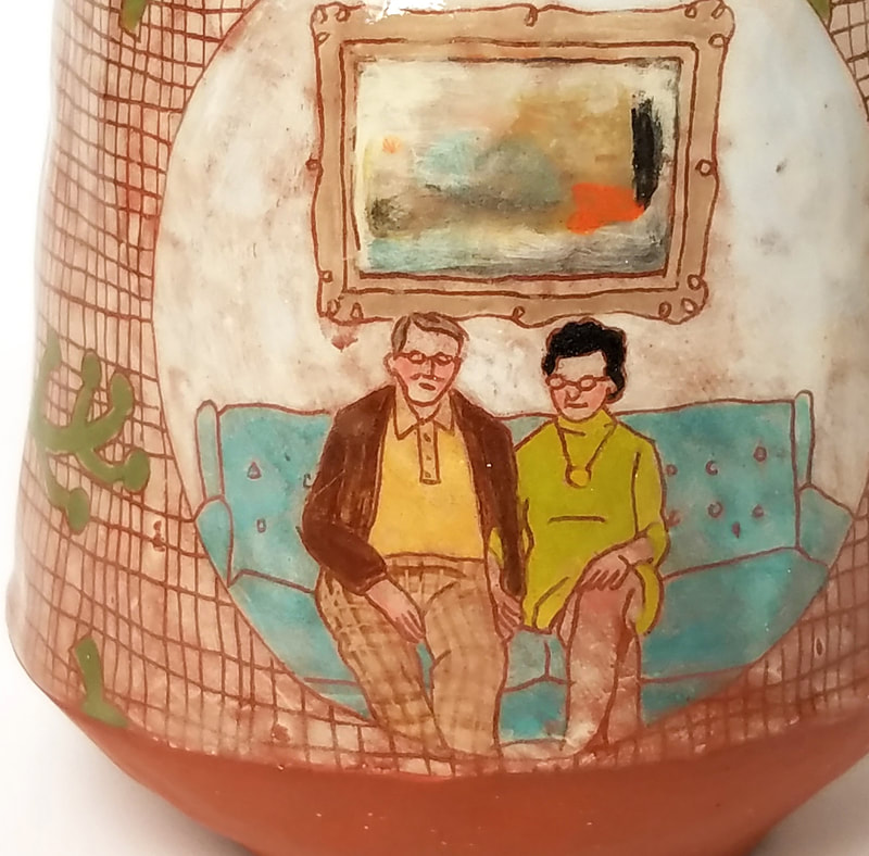 close up of middle aged white man and woman on a chesterfield with an abstract painting behind them, image is decoration on a terracotta cup